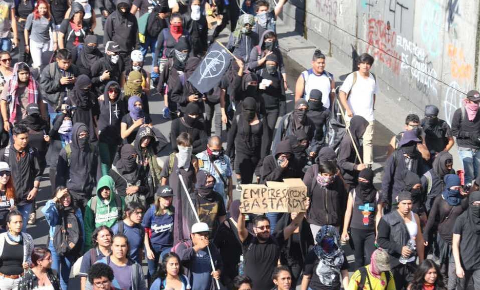 Photo of Encapuchados vandalizan y lanzan petardos en marcha del 2 de octubre