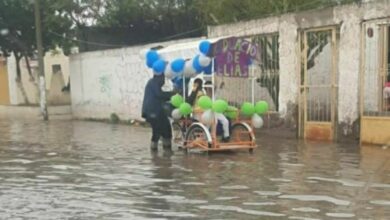 Photo of A pesar de las calles inundadas papá adorna su triciclo y lleva a su hijo a su graduación