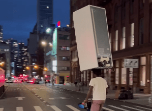 Photo of Lleva refrigerador sobre su cabeza y en bicicleta